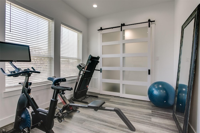 2239 Lovedale Ave Unit 105, Dallas, TX 75235 - workout room featuring baseboards, recessed lighting, a barn door, and wood finished floors