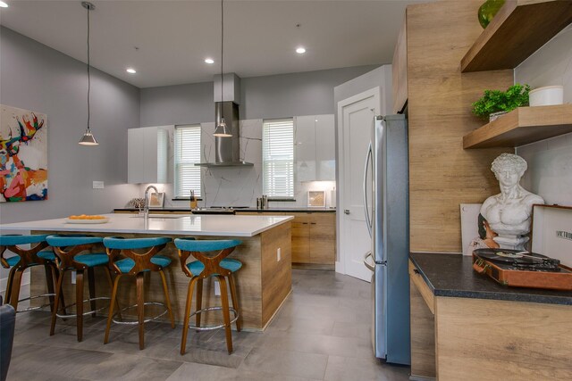 2239 Lovedale Ave Unit 105, Dallas, TX 75235 - kitchen with a sink, a breakfast bar, freestanding refrigerator, wall chimney exhaust hood, and modern cabinets