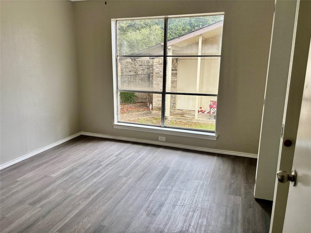 8805 N Normandale St, Fort Worth, TX 76116 - empty room featuring baseboards, wood finished floors, and plenty of natural light
