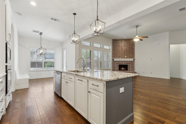 3612 Green Mountain Pl, Mckinney, TX 75070 - kitchen with a sink, ceiling fan, a brick fireplace, stainless steel appliances, and dark wood finished floors