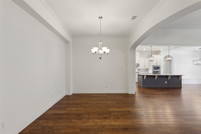3612 Green Mountain Pl, Mckinney, TX 75070 - unfurnished living room featuring a chandelier, arched walkways, dark wood finished floors, crown molding, and baseboards