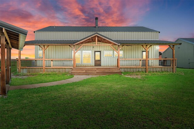 back of house with metal roof, covered porch, and board and batten siding