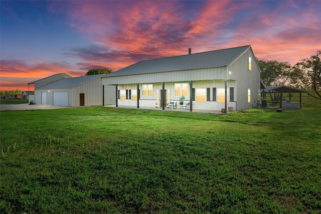 view of front of home with a lawn, metal roof, and driveway