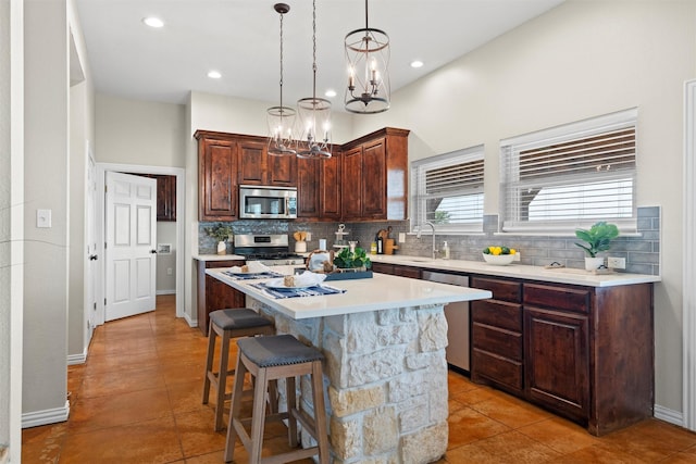 kitchen with light countertops, appliances with stainless steel finishes, decorative backsplash, and light tile patterned flooring