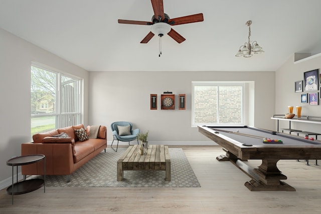 recreation room featuring wood finished floors, plenty of natural light, and ceiling fan with notable chandelier