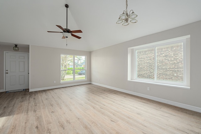 interior space with high vaulted ceiling, wood finished floors, baseboards, and ceiling fan with notable chandelier