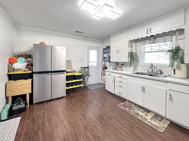 1700 4th St, Brownwood, TX 76801 - kitchen featuring white cabinetry, freestanding refrigerator, visible vents, dark wood finished floors, and a sink