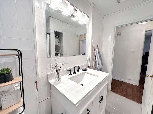 1700 4th St, Brownwood, TX 76801 - bathroom with vanity, tile walls, and decorative backsplash