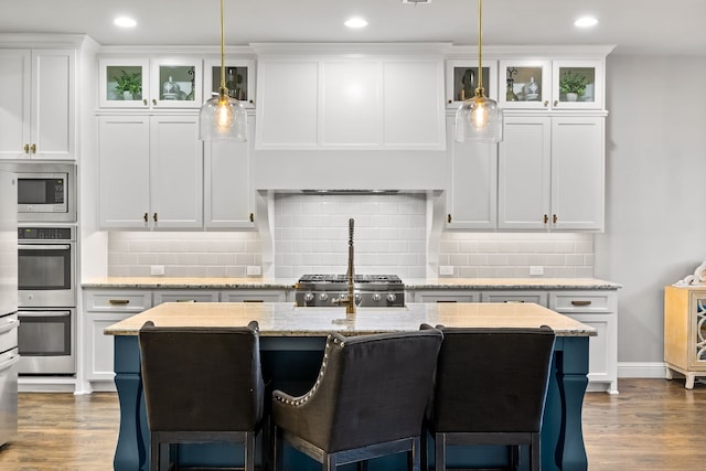 3510 Springbell St, Celina, TX 75009 - kitchen featuring dark wood-type flooring, stainless steel appliances, a kitchen breakfast bar, white cabinets, and recessed lighting