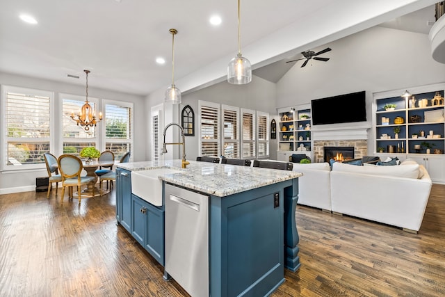 3510 Springbell St, Celina, TX 75009 - kitchen with blue cabinets, a sink, stainless steel dishwasher, ceiling fan, and a stone fireplace