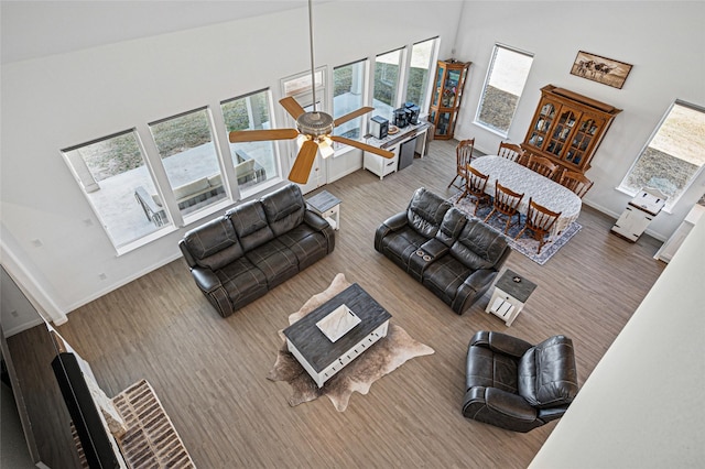 197 Spanish Moss Trl, Rhome, TX 76078 - living area featuring a towering ceiling, baseboards, wood finished floors, and a ceiling fan