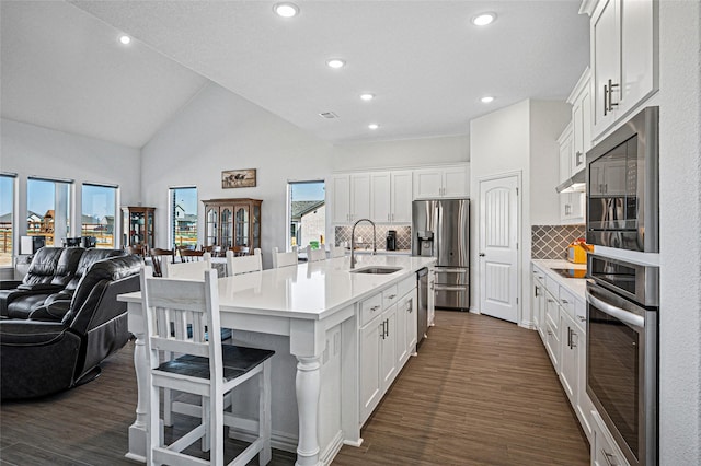 kitchen featuring appliances with stainless steel finishes, open floor plan, white cabinetry, and a sink