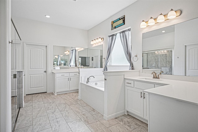 bathroom featuring a sink, two vanities, walk in shower, a garden tub, and marble finish floor