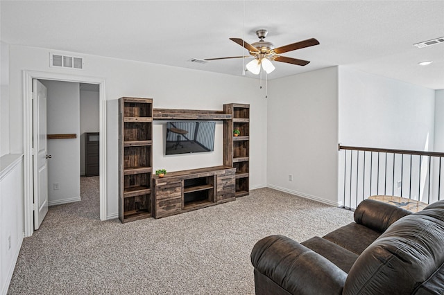 carpeted living room featuring a ceiling fan, visible vents, and baseboards