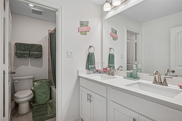 full bathroom with visible vents, toilet, double vanity, and a sink