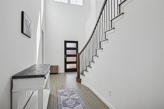 197 Spanish Moss Trl, Rhome, TX 76078 - foyer featuring wood finished floors, baseboards, a high ceiling, stairs, and a textured wall