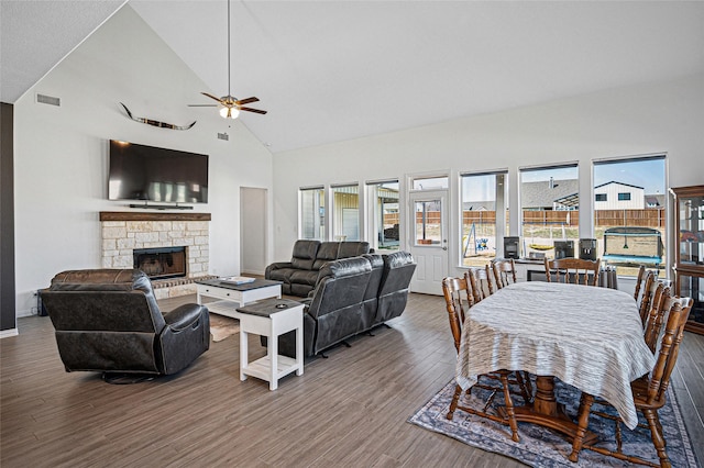 197 Spanish Moss Trl, Rhome, TX 76078 - living room with high vaulted ceiling, ceiling fan, wood finished floors, a stone fireplace, and baseboards