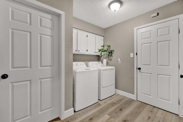 3509 Appalachian Ct, Plano, TX 75075 - laundry area featuring washing machine and clothes dryer, cabinet space, light wood-style flooring, a textured ceiling, and a textured wall