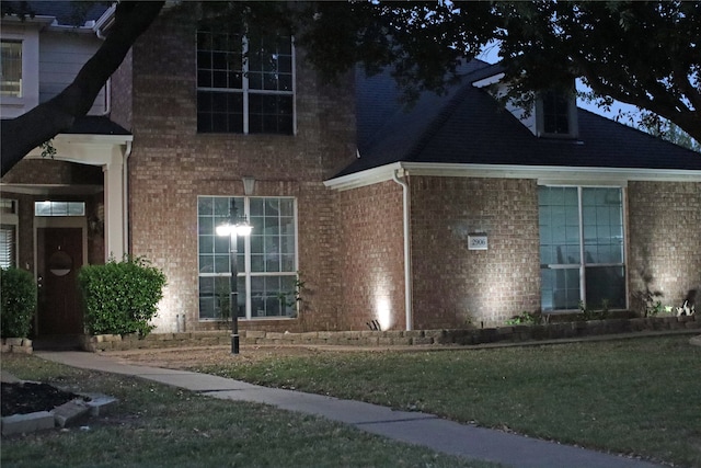 view of property exterior featuring a lawn and brick siding
