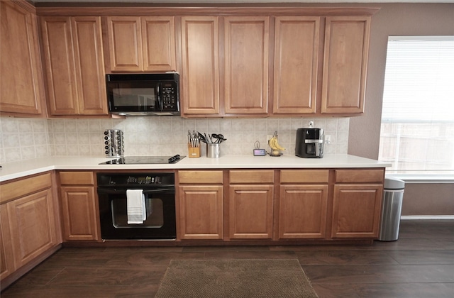 kitchen featuring light countertops, decorative backsplash, and black appliances