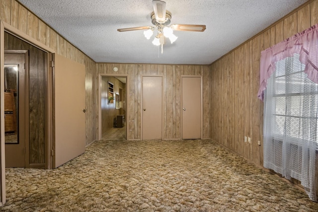 609 E Main, Omaha, TX 75571 - interior space featuring a textured ceiling, ceiling fan, and wood walls