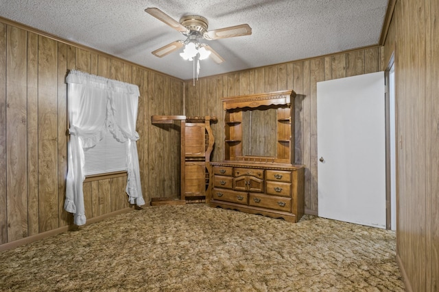 609 E Main, Omaha, TX 75571 - carpeted bedroom featuring crown molding, wooden walls, ceiling fan, and a textured ceiling
