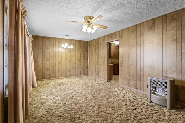 609 E Main, Omaha, TX 75571 - unfurnished room featuring ceiling fan with notable chandelier, carpet, a textured ceiling, wooden walls, and heating unit
