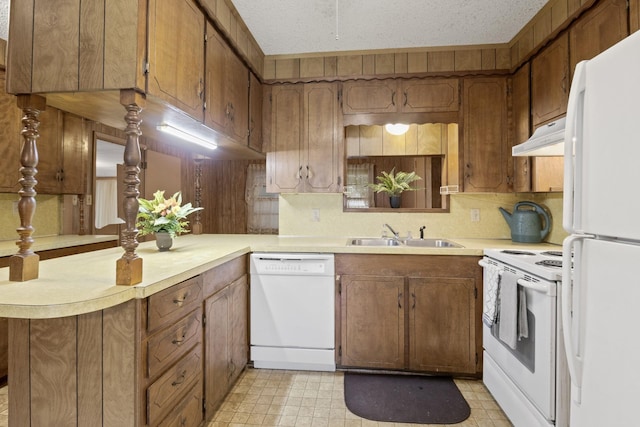609 E Main, Omaha, TX 75571 - kitchen with light countertops, white appliances, under cabinet range hood, a sink, and light floors