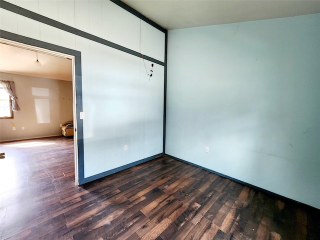 unfurnished room with dark wood finished floors