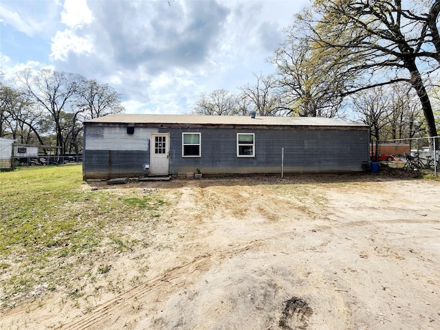 back of property with a lawn and fence