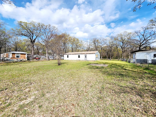 view of yard featuring an outdoor structure and fence