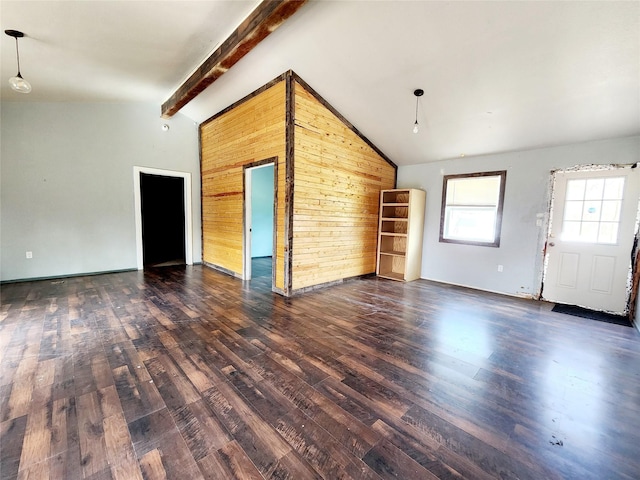 unfurnished living room featuring vaulted ceiling with beams, wood finished floors, and wood walls