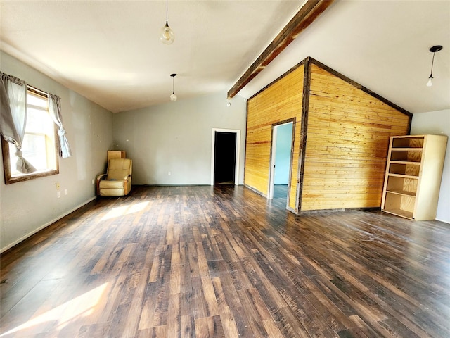 empty room with lofted ceiling with beams, wooden walls, and wood finished floors