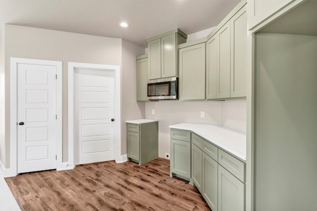 309 Pecan Ln, Tolar, TX 76476 - kitchen featuring stainless steel microwave, light wood-type flooring, recessed lighting, light countertops, and baseboards