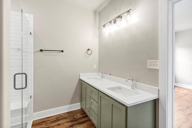 309 Pecan Ln, Tolar, TX 76476 - bathroom with a stall shower, wood finished floors, baseboards, and double vanity