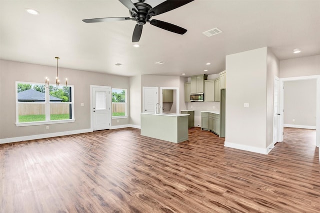 309 Pecan Ln, Tolar, TX 76476 - unfurnished living room featuring wood finished floors, baseboards, ceiling fan, a chandelier, and a sink