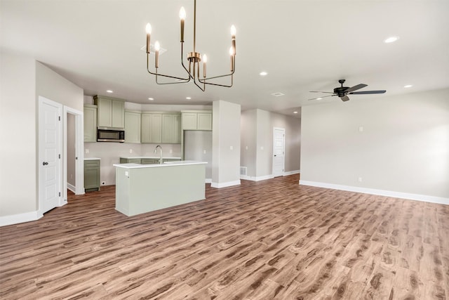 309 Pecan Ln, Tolar, TX 76476 - kitchen featuring stainless steel microwave, light wood-type flooring, a sink, recessed lighting, and a kitchen island with sink