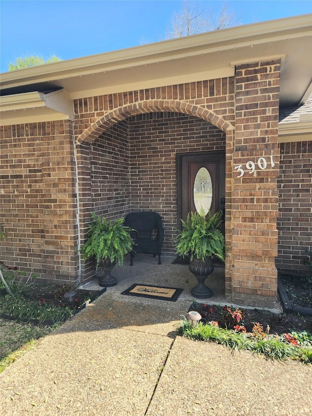 doorway to property with brick siding