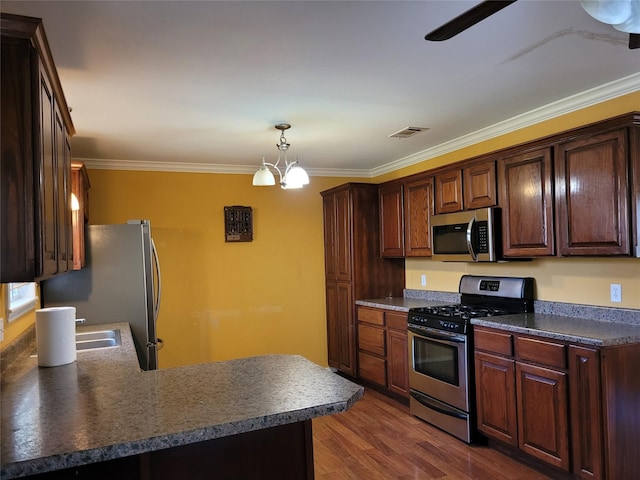 kitchen featuring crown molding, dark countertops, stainless steel appliances, and visible vents