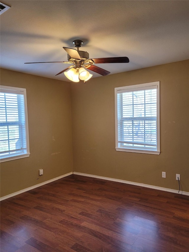 empty room featuring baseboards, a ceiling fan, and wood finished floors