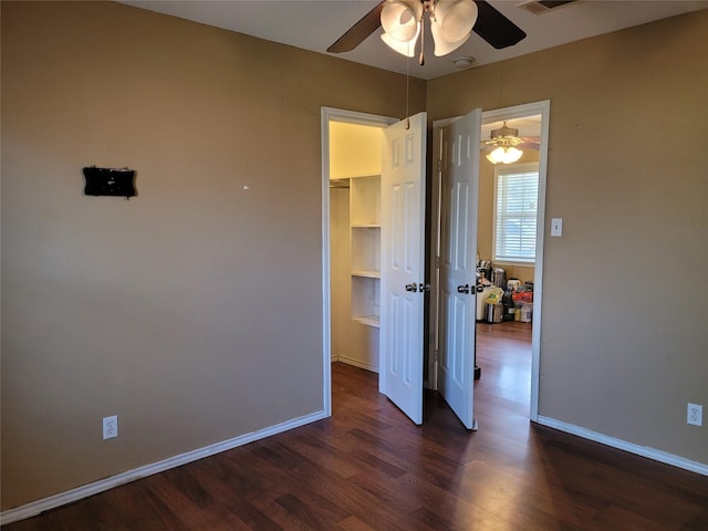 unfurnished bedroom with visible vents, baseboards, ceiling fan, and dark wood-style flooring