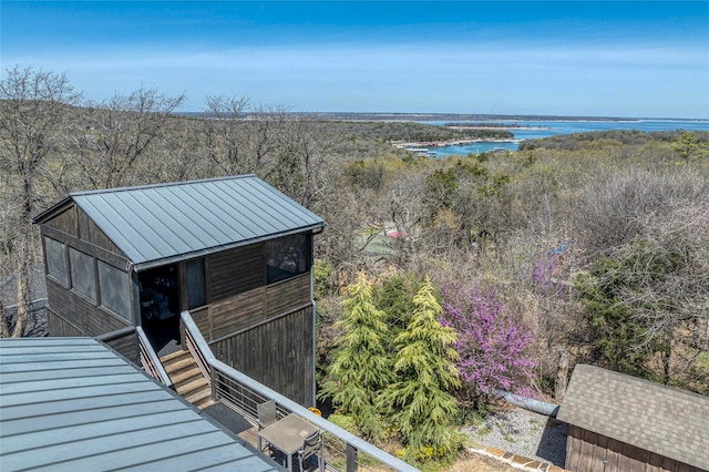exterior space with a wooded view and a water view