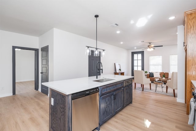 kitchen with stainless steel dishwasher, visible vents, a sink, and light wood-style floors