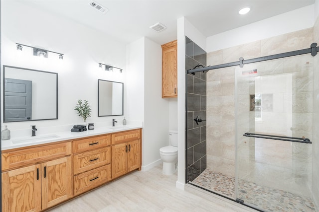 bathroom with toilet, visible vents, a sink, and a stall shower