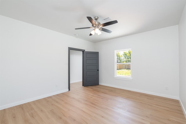 empty room with light wood-style flooring, visible vents, baseboards, and ceiling fan