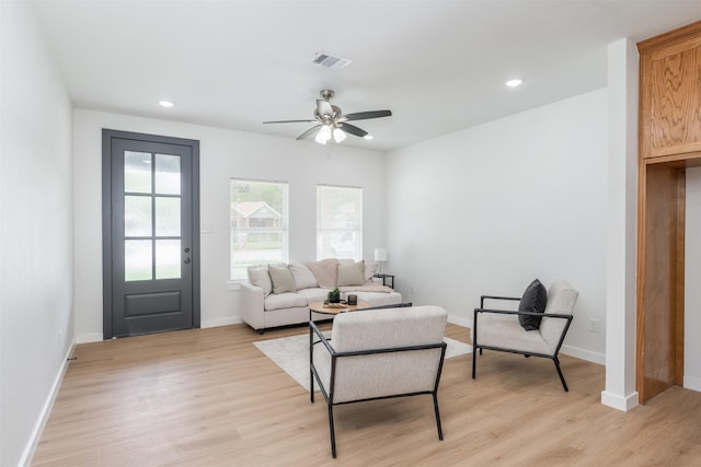 living area featuring baseboards, a ceiling fan, light wood-style floors, and recessed lighting