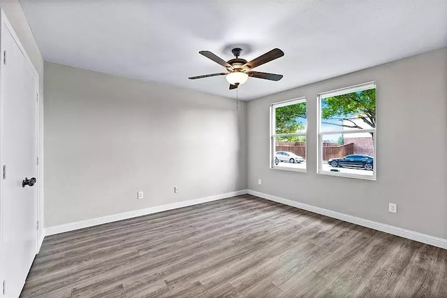unfurnished room featuring baseboards, wood finished floors, and ceiling fan