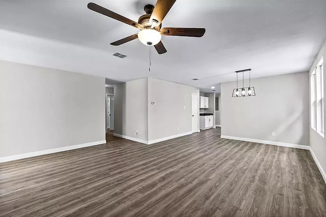 unfurnished living room with dark wood finished floors, baseboards, visible vents, and ceiling fan