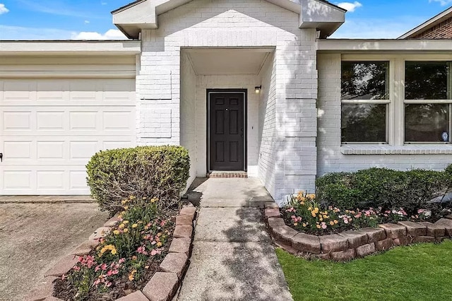 property entrance featuring a garage and brick siding