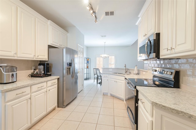 kitchen with a sink, decorative backsplash, light tile patterned flooring, stainless steel appliances, and visible vents
